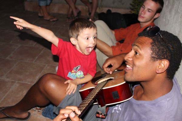 image of Will Matthews playing guitar with a kid