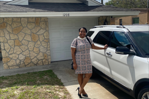 New homeowner, Yvette, stands proudly in front of her new home