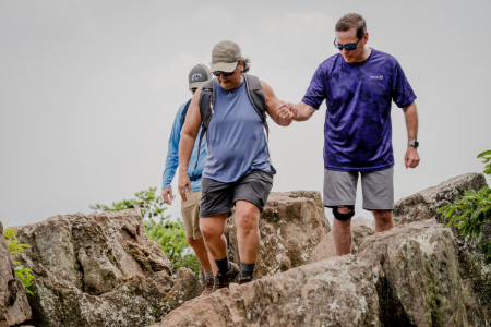 Truist teammate Mark Case a female hiker navigate rocky terrain while on a hike