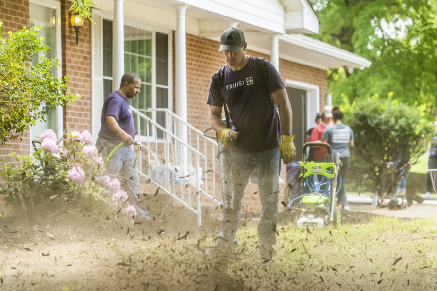 Truist volunteers doing yard work for new home