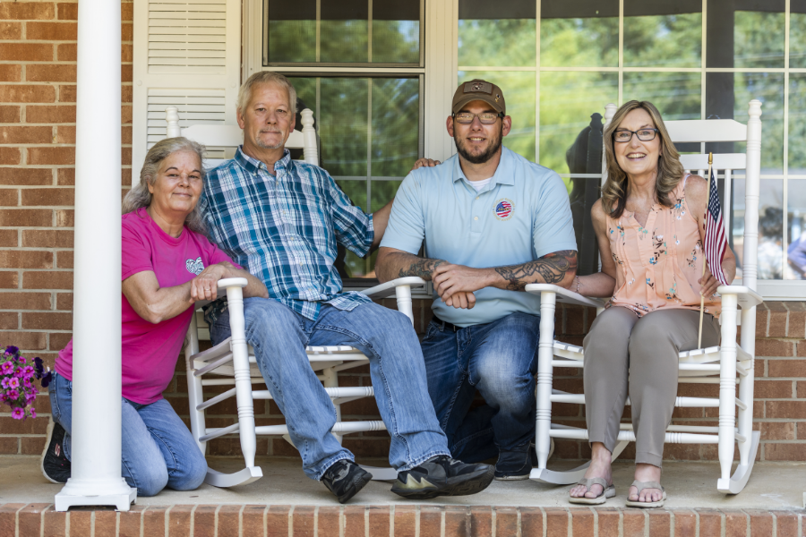 Veteran and family members sitting on porch