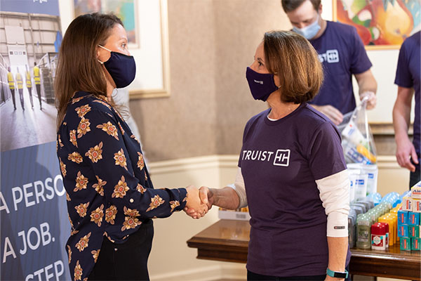 Image of Truist Volunteer shaking hands with First Step organization