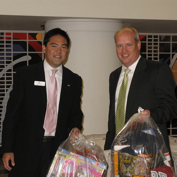 Image of Brent Yamatto holding raffle basket with coworker