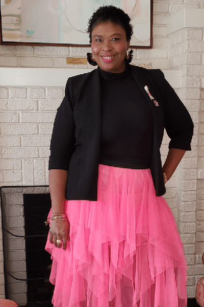 Image of Charmaine Tyson in pink skirt and black shirt and blazer